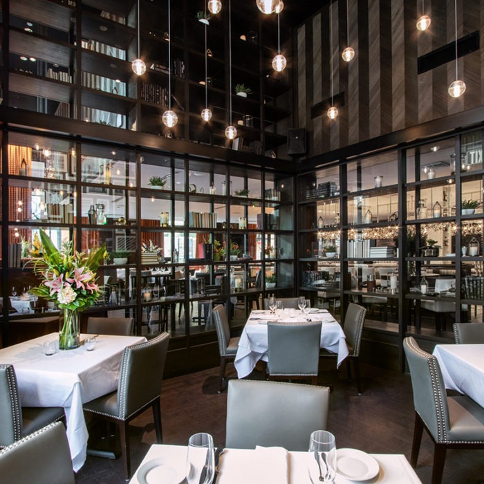 A restaurant space surrounded by a glass wall and shelf.