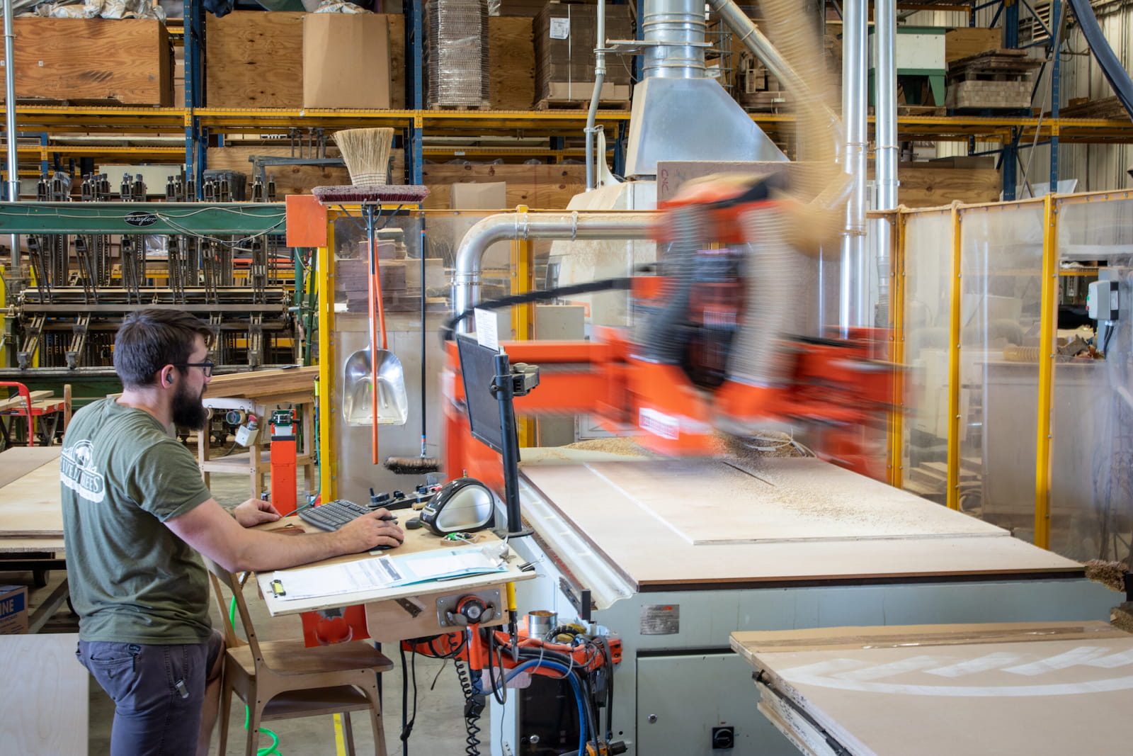 A Seven Trees Woodworking employee operating a CNC machine